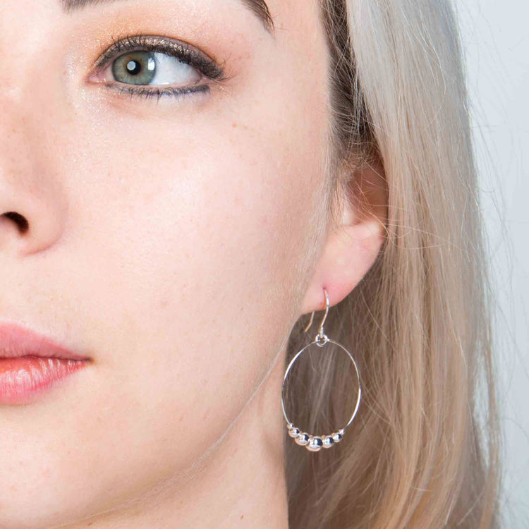 Aretes de contorno circular con esferas de plata